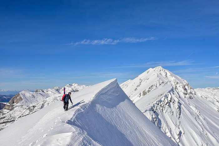 Der Tourenskifahrer genießt die Aussicht auf einen schneebedeckten Berg