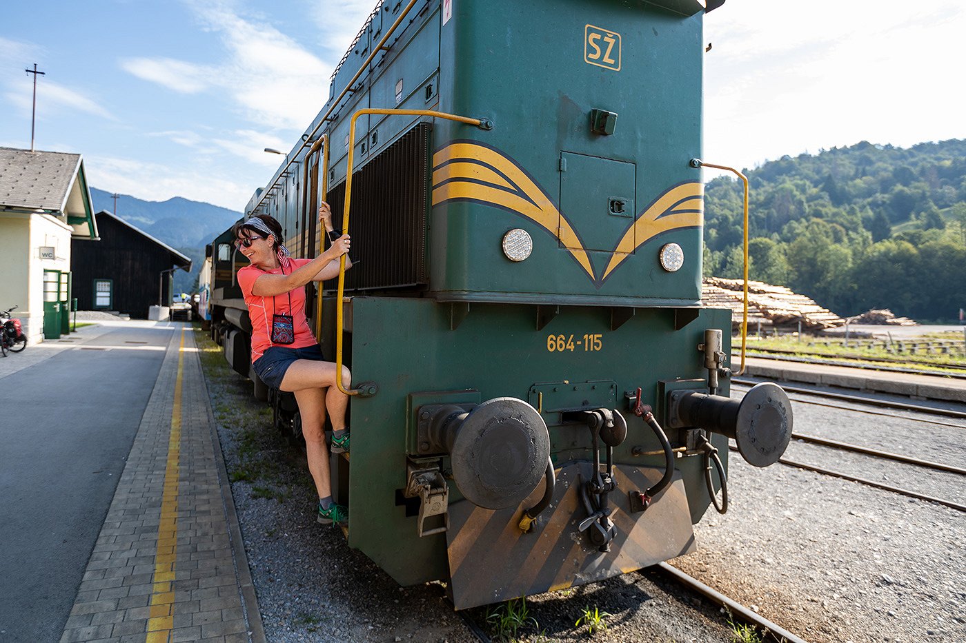 A smiling passenger gets on a train at the train station.