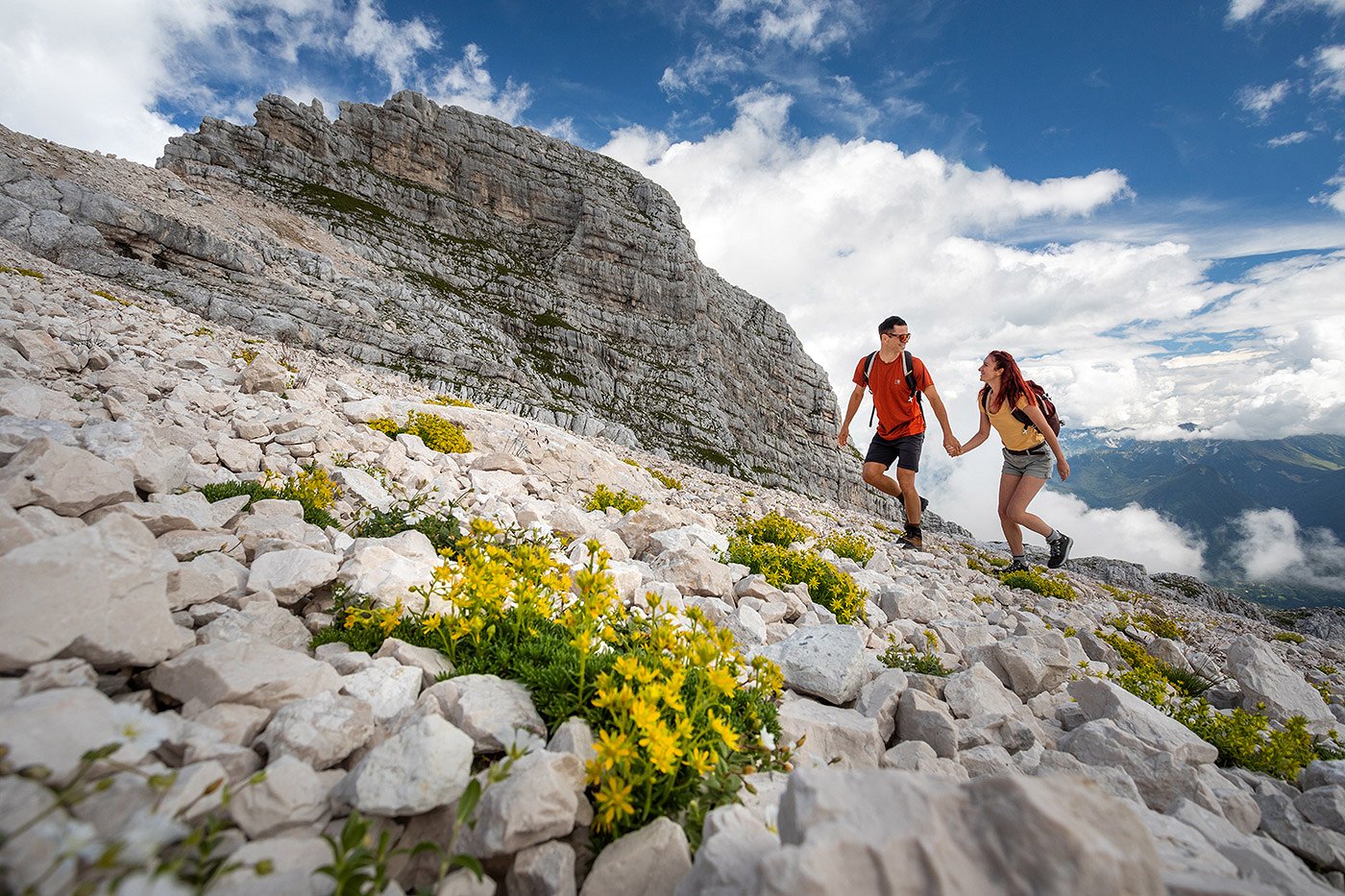 Das Paar genießt einen Spaziergang mit Bergblumen auf Kanin