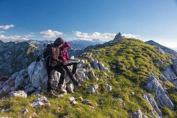 Hikers at the top of the mountain study the map