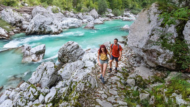 Pohodnika se sprehajata po Juliana Trail ob smaragdni reki Soči